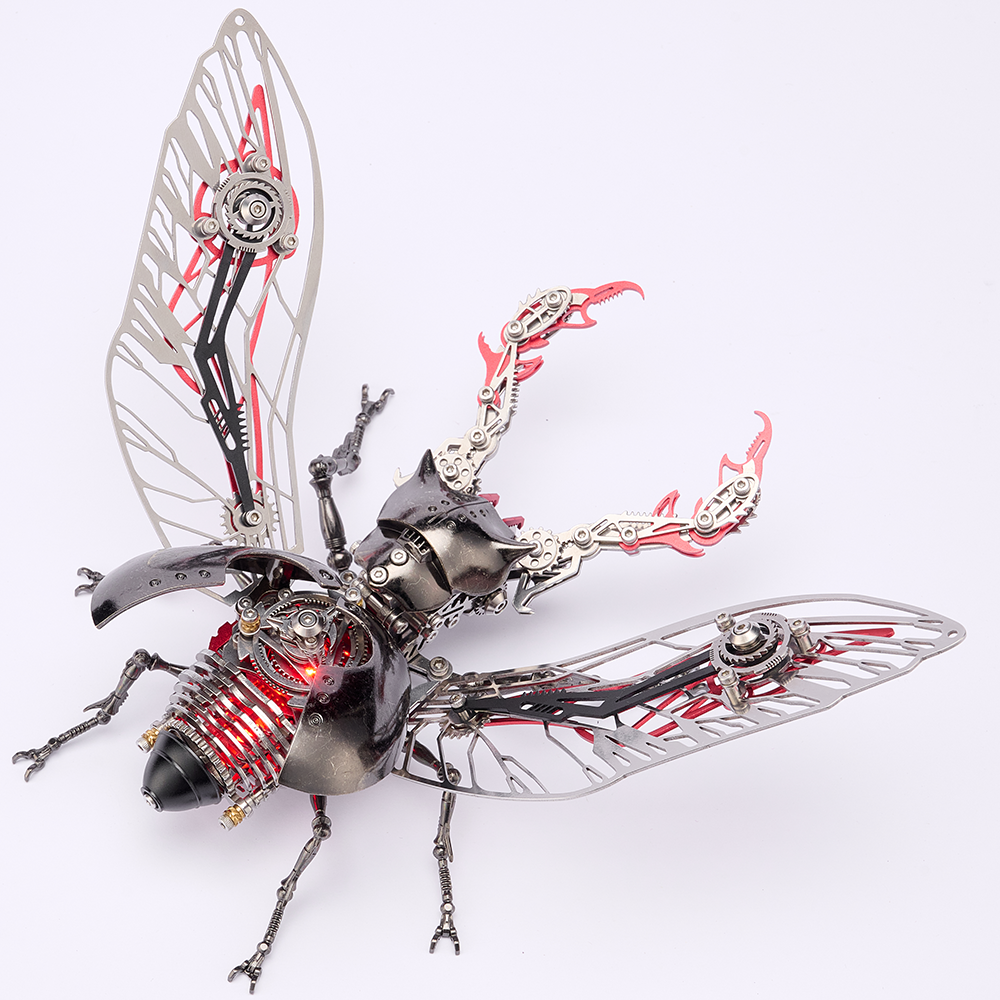 A steampunk beetle sculpture made of metallic parts, featuring silver mechanical wings, a black and silver beetle body, and red internal gears and tubes, photographed on a clean white background.