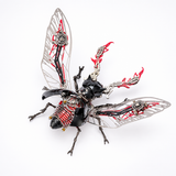 A highly detailed, steampunk-style insect sculpture or collectible model, resembling a cicada or beetle, featuring metallic silver wings with intricate gear mechanisms, a glossy black body, and red flame-like accents on its thorax and back, set against a plain white background.